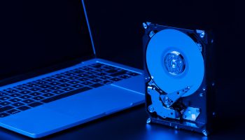 hard-drive-with-blue-light-laptop-high-angle